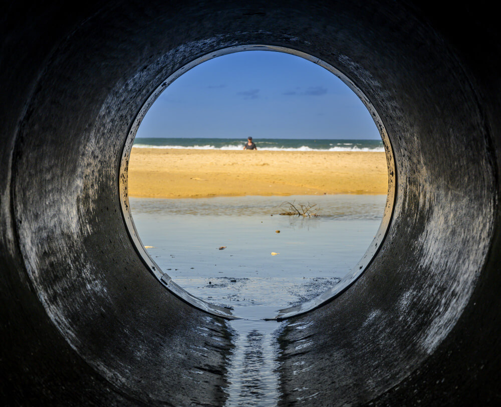 look-form-pipe-looking-beach-surrounded-by-sea-with-people-it-sunlight (1)